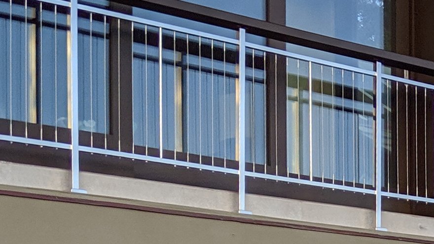 Balcony railing with vertical cable.