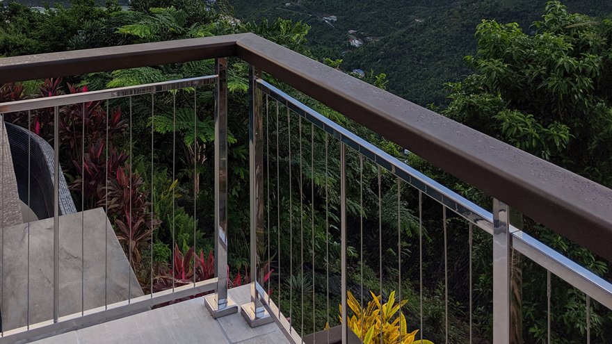 Vertical cable deck rail with wood handrail and a mirror finish make this modern railing system stand out.
